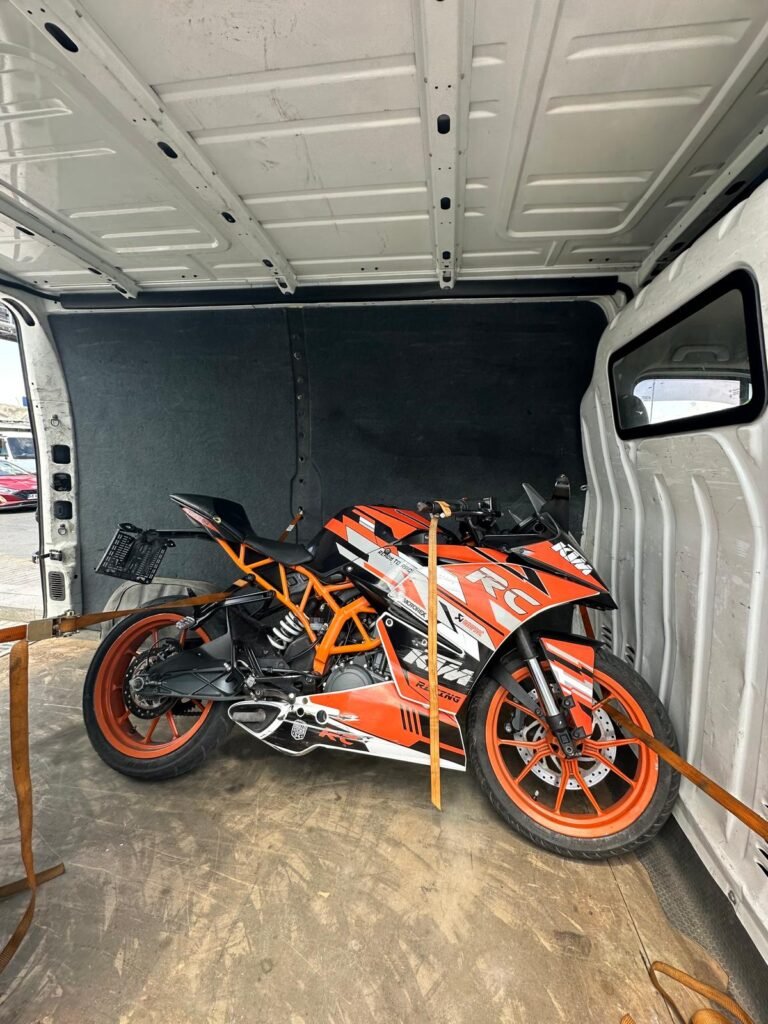 Kapalı kasa araçta güvenli şekilde sabitlenen motosiklet
